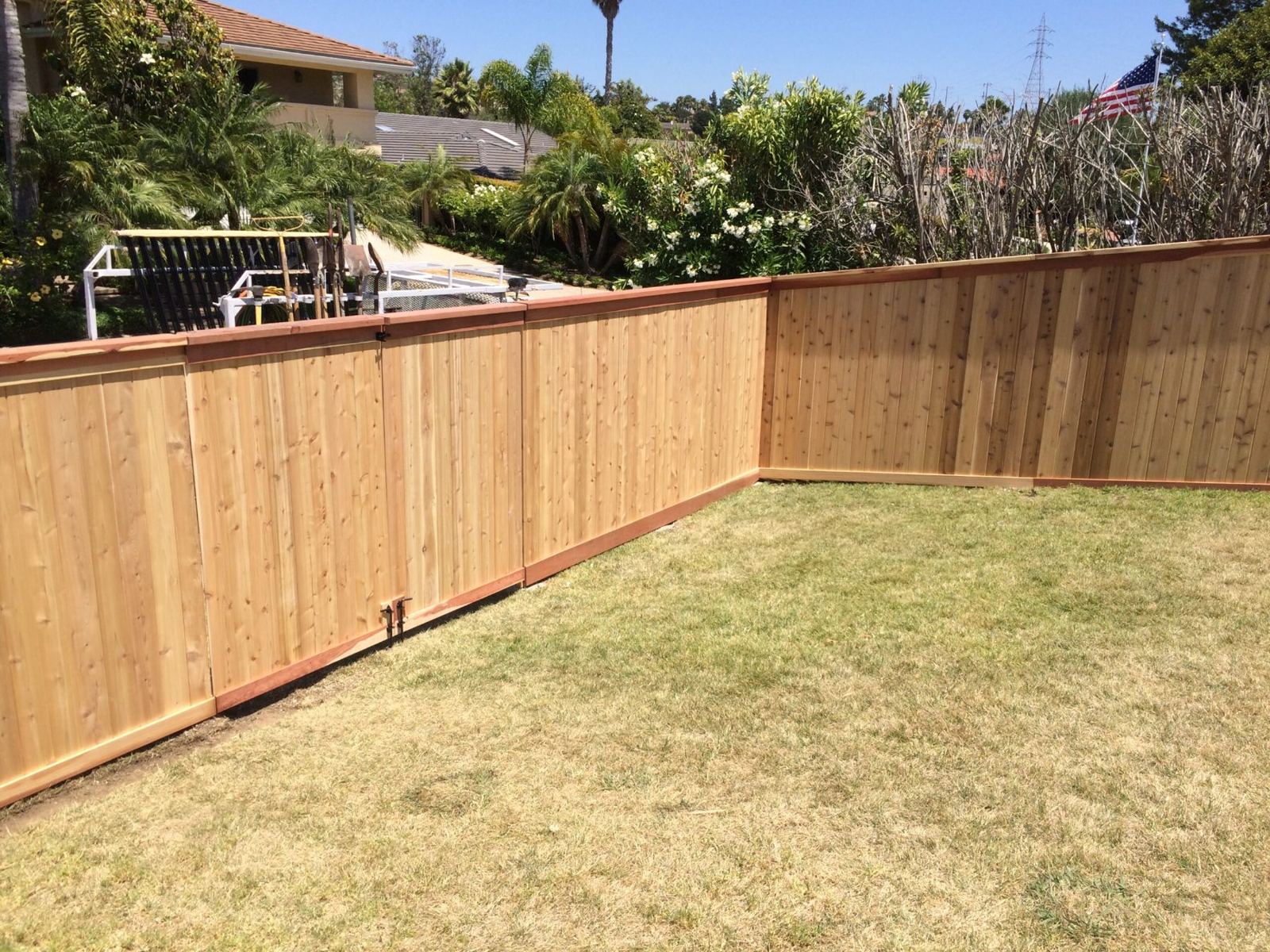 New wood privacy fence with a matching gate around a backyard